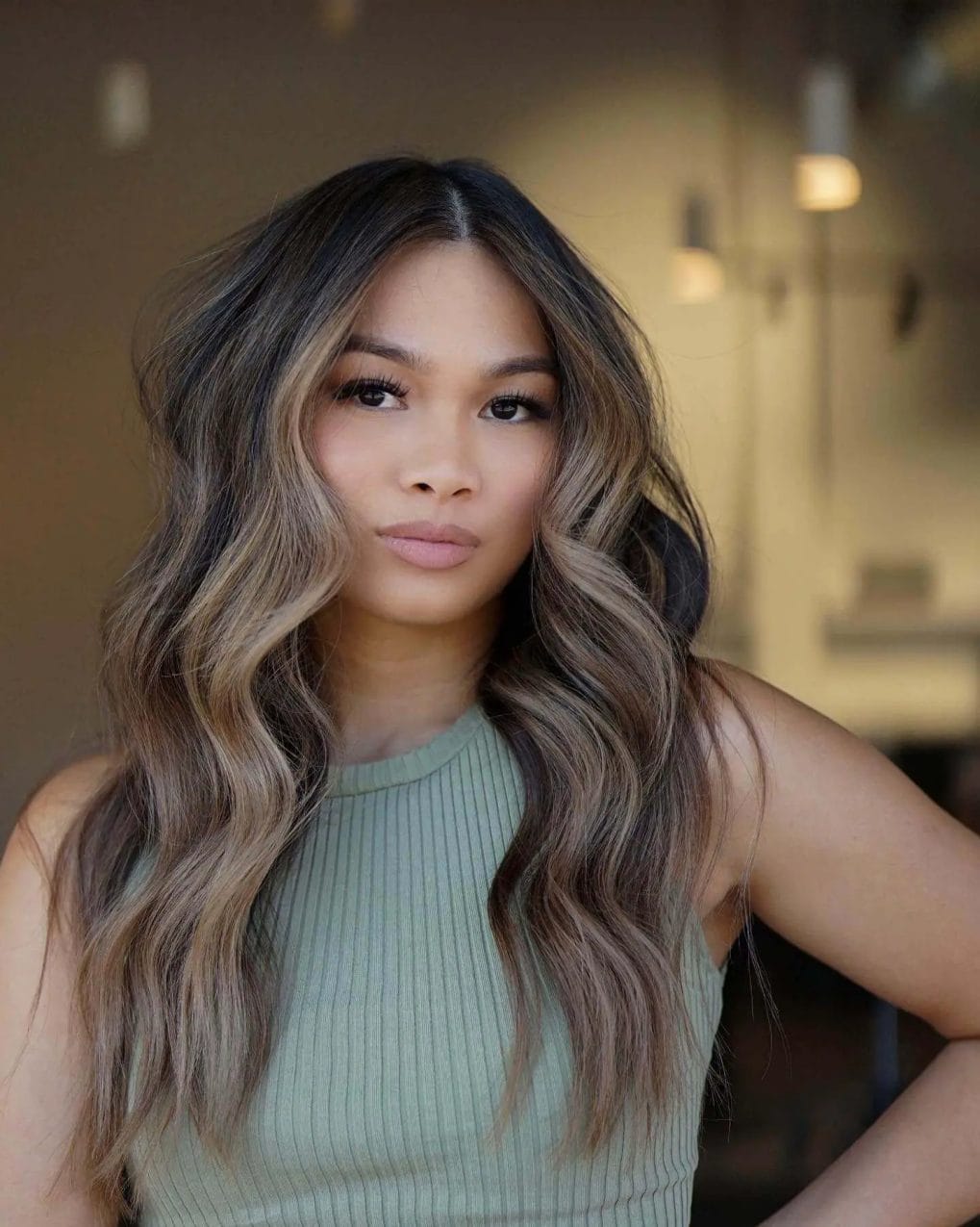 Cool ash and warm beige balayage with voluminous waves on hair.