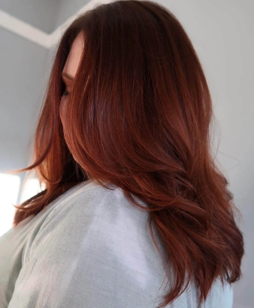 Modern lob in dimensional copper with amber-toned ends and soft waves.