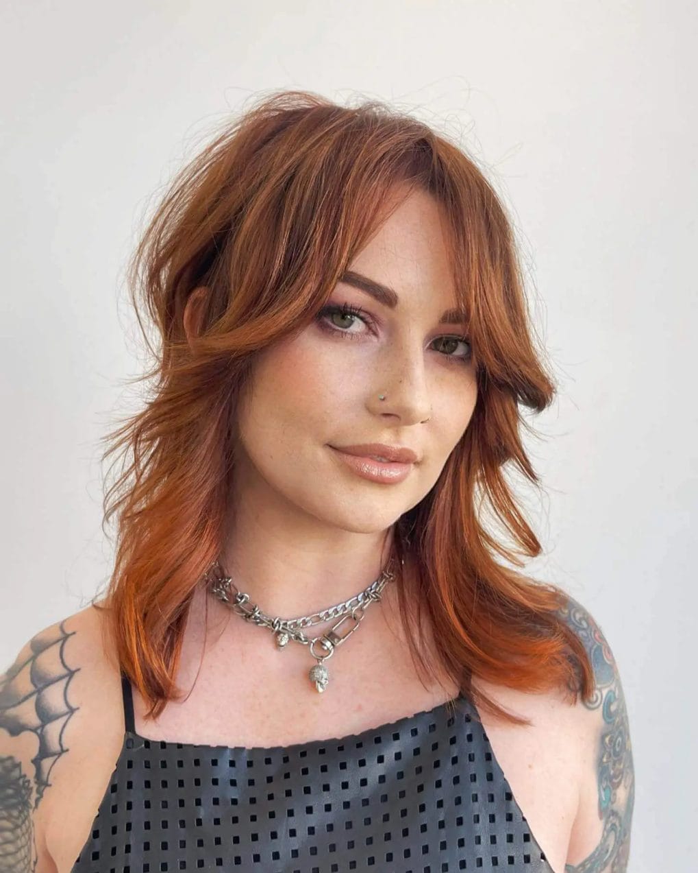 Medium fiery copper 60s shag cut with textured layers and soft curtain bangs.