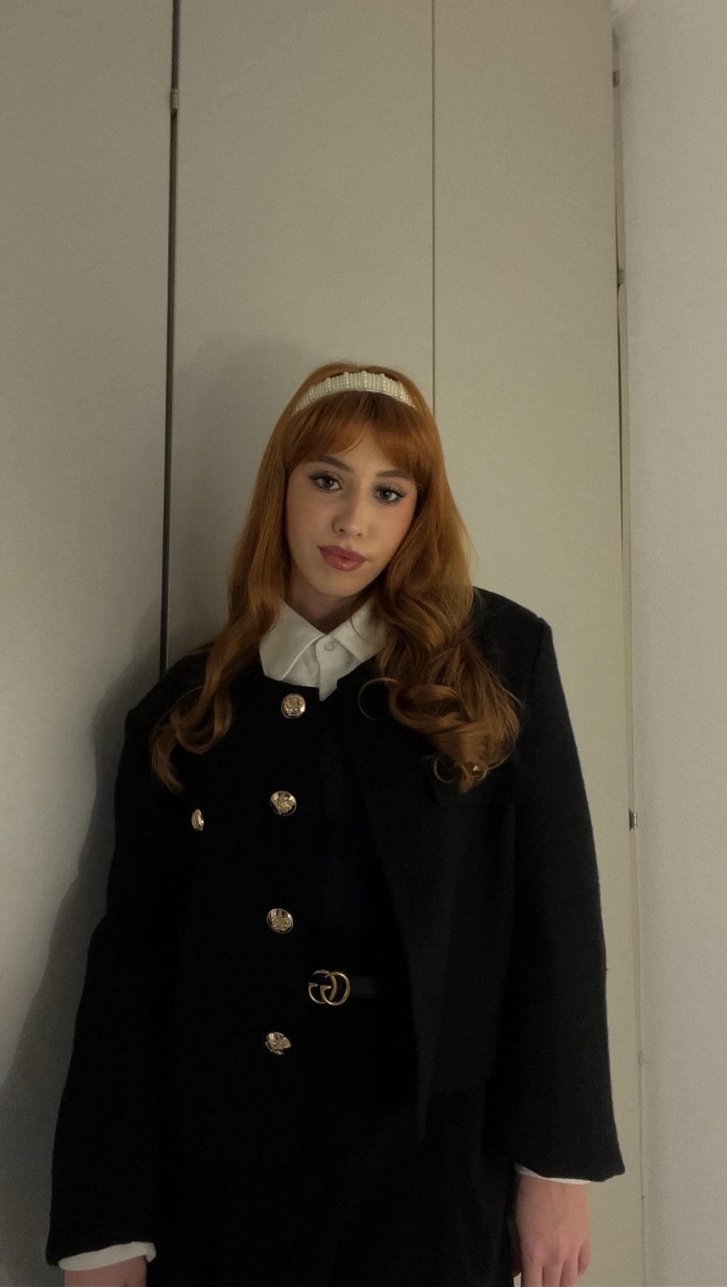 Copper-toned chin-length bob with straight-across bangs and soft curling tips