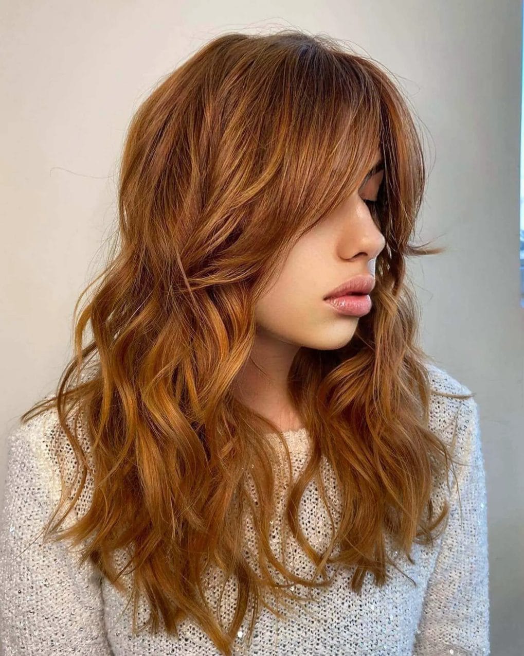 Layered copper waves with long, draping textured bangs