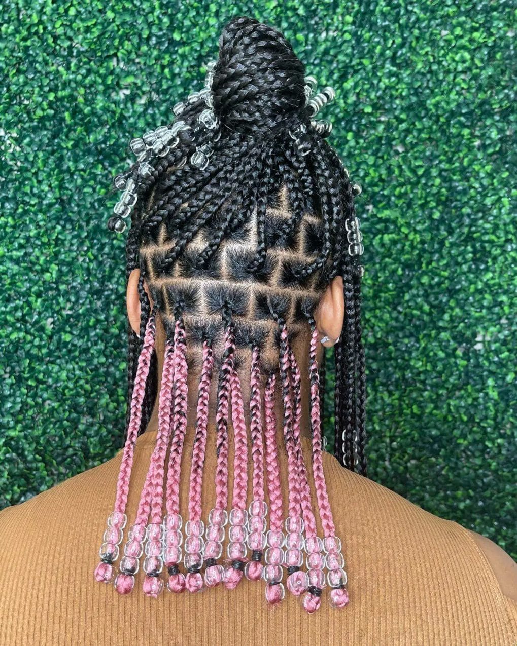 Cornrows converging into a high bun with pink ombre and sparkling clear beads.