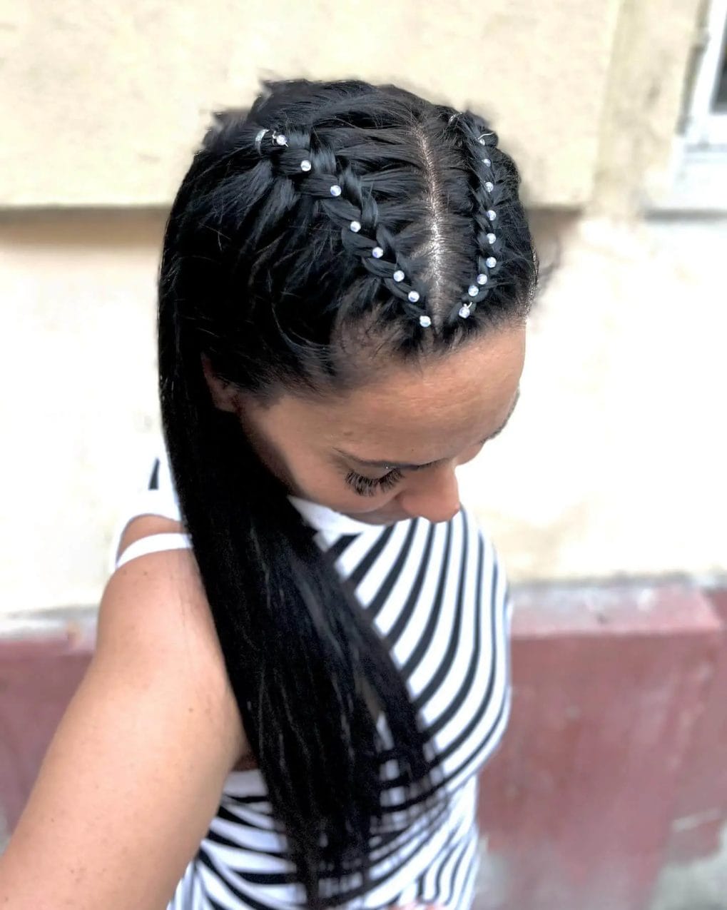 Cornrow braids with small white beads transitioning to long, straight locks.