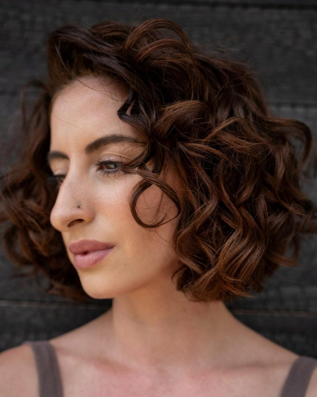 Curly French bob framing face with chocolate curls