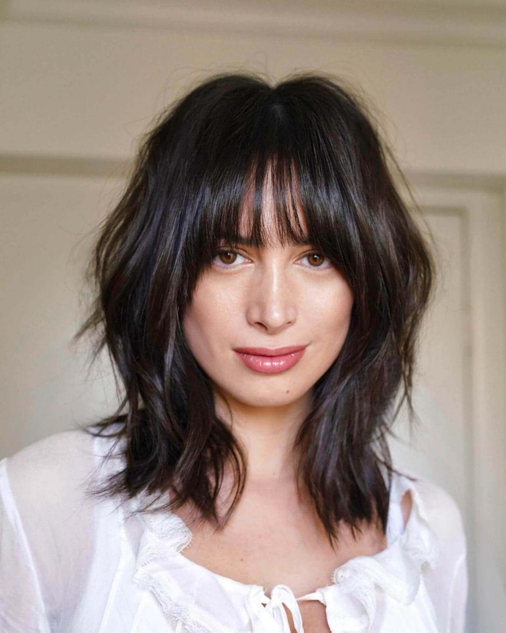 Shoulder-length dark brown waves with see-through bangs