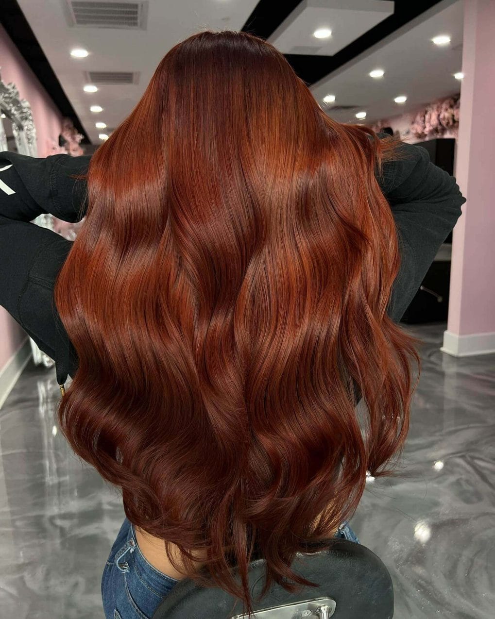 Dark copper roots blending into glossy auburn waves with Hollywood style curls.