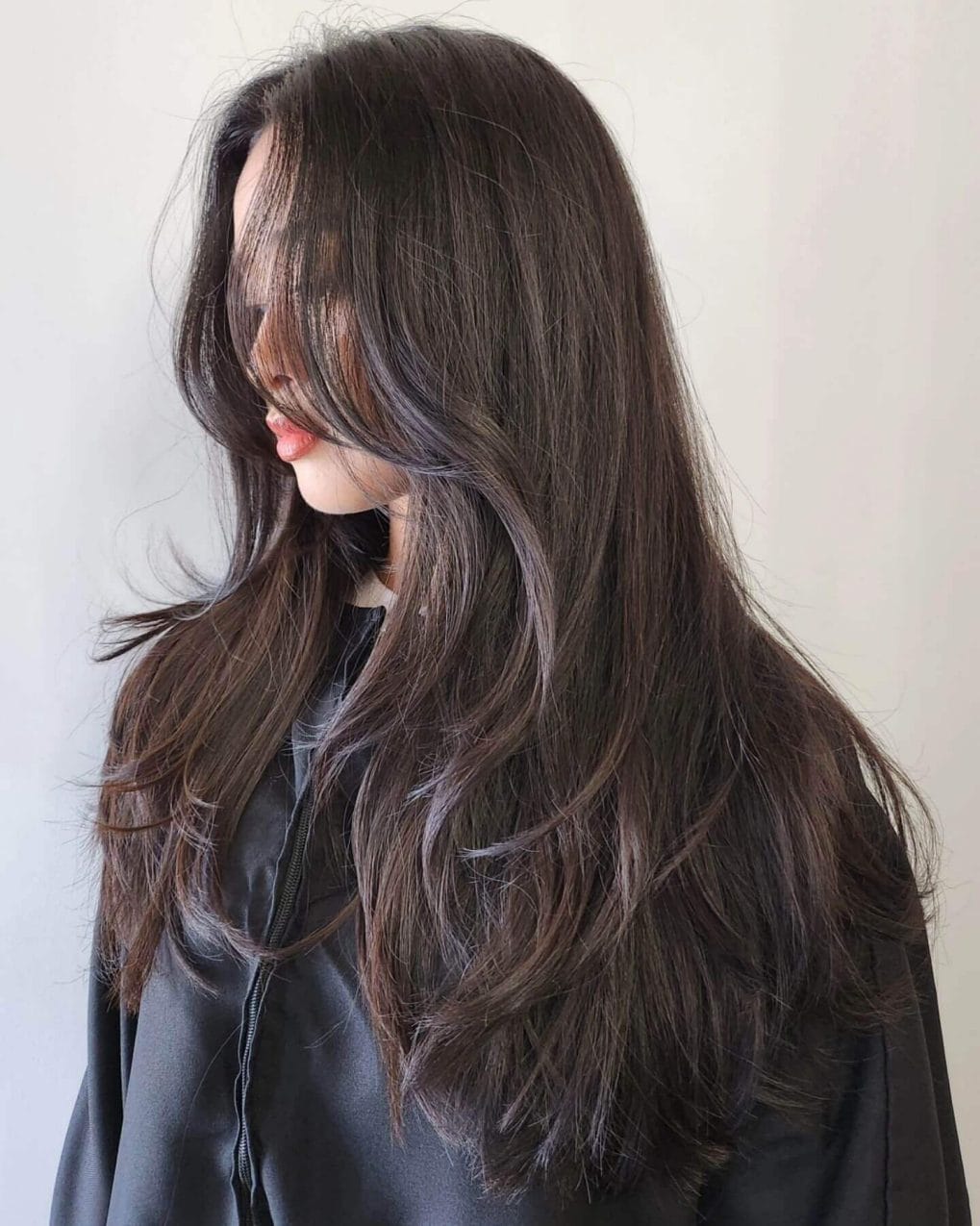 Dark flowing layers with 90s curtain bangs effortless