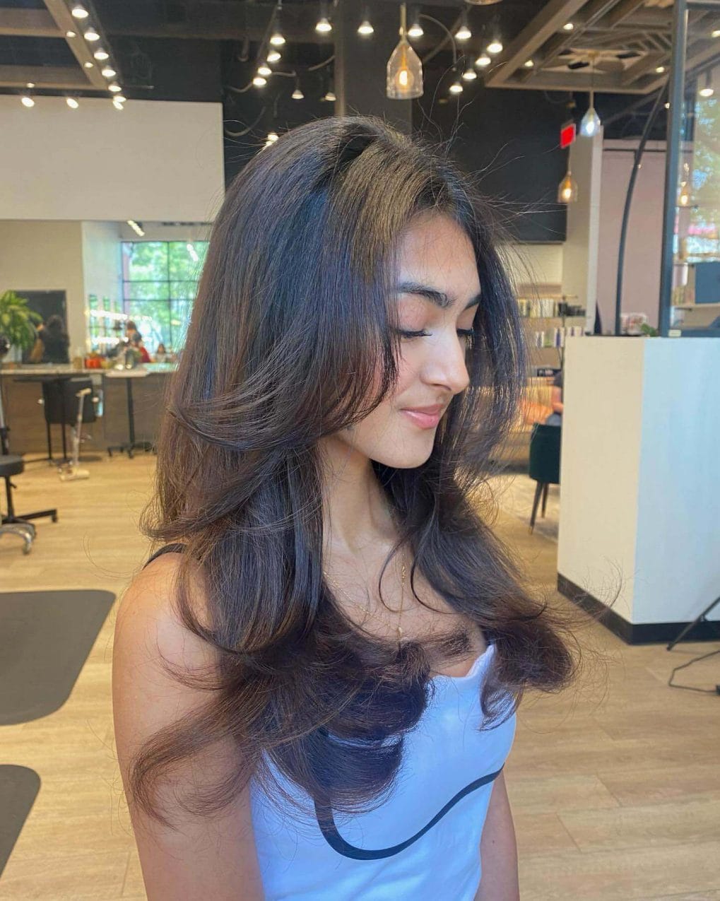 Dark flowing layers with 90s curtain bangs elegance