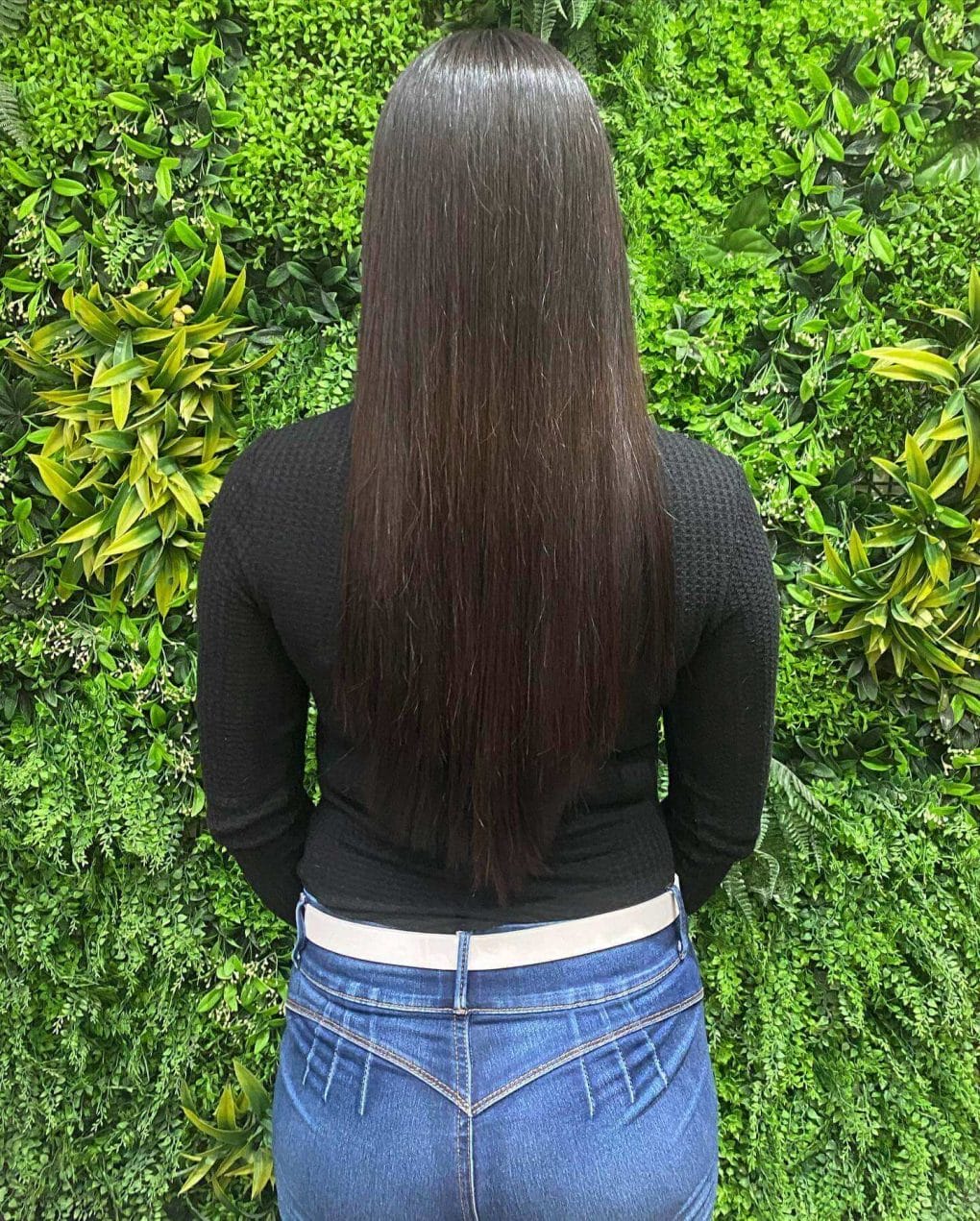 Sleek straight hair with dark shine in a V-cut style.