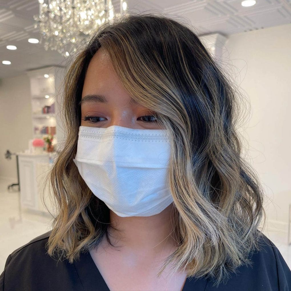 Balayage blend of deep brown and sun-kissed blonde with tousled waves.