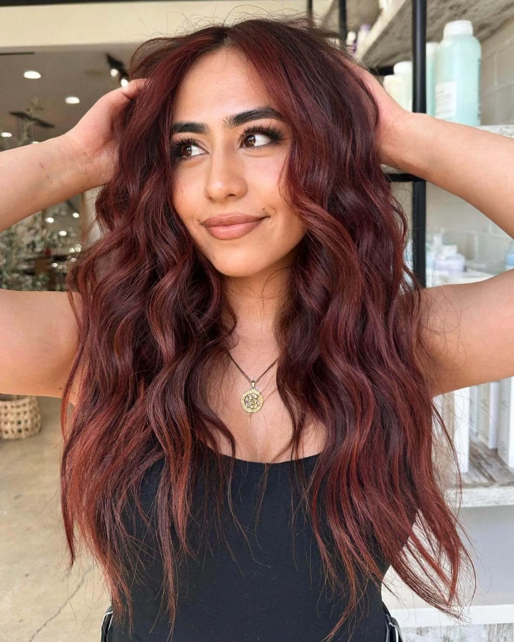 Deep burgundy copper hair in long layers with soft, tousled waves.