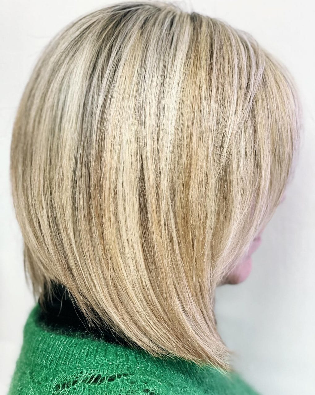 Blonde pixie bob with long side-swept bangs and subtle highlights for added dimension