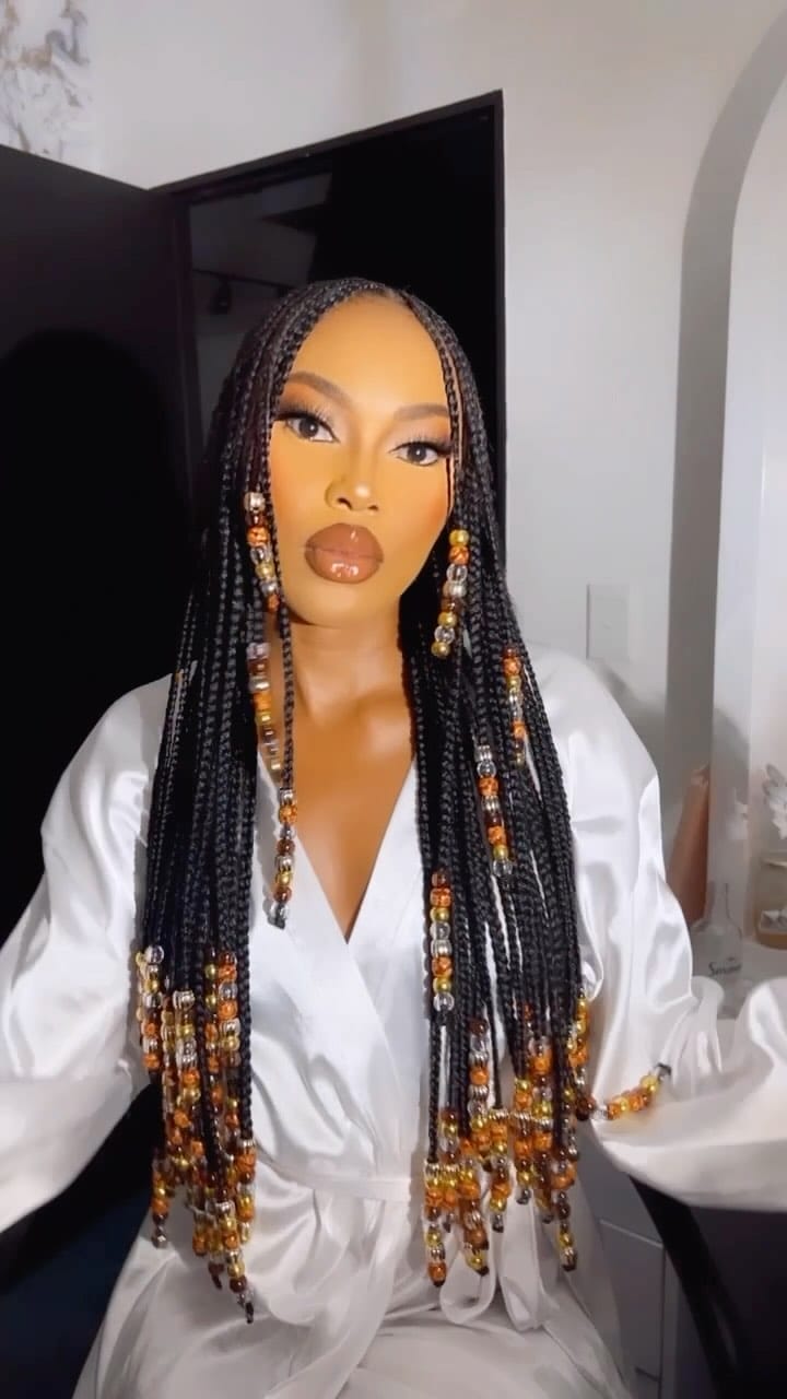 Sleek braids adorned with golden beads for a bold statement
