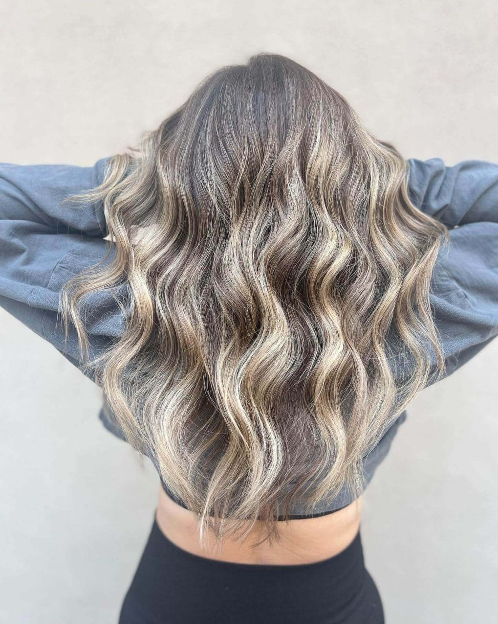 Full waves in dusty ash to platinum blonde balayage, capturing wintry frost.