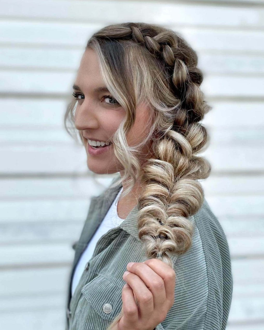 Side Dutch braid transitions into a blonde-highlighted bubble ponytail.