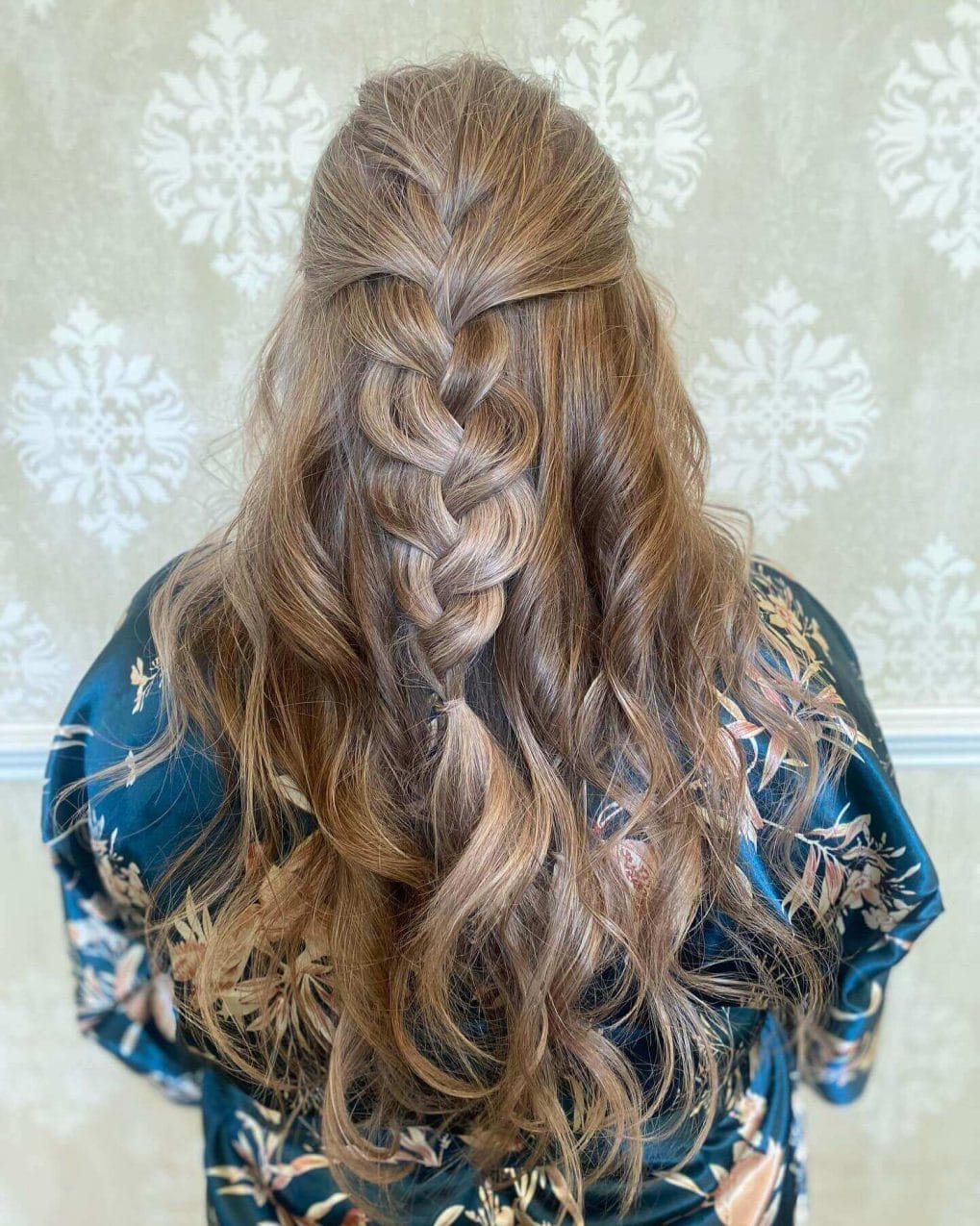 Soft caramel waves finish in a stunning Dutch braid