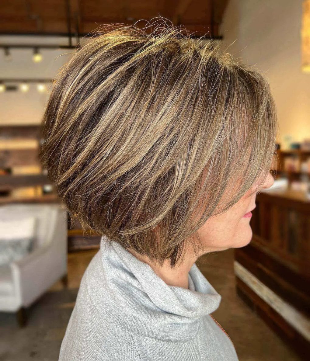 Dynamic layered bob with textured cool blonde and warm brown highlights.