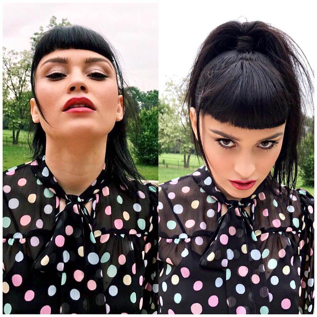 Sleek high black ponytail paired with bold straight bangs, creating an edgy and confident look.