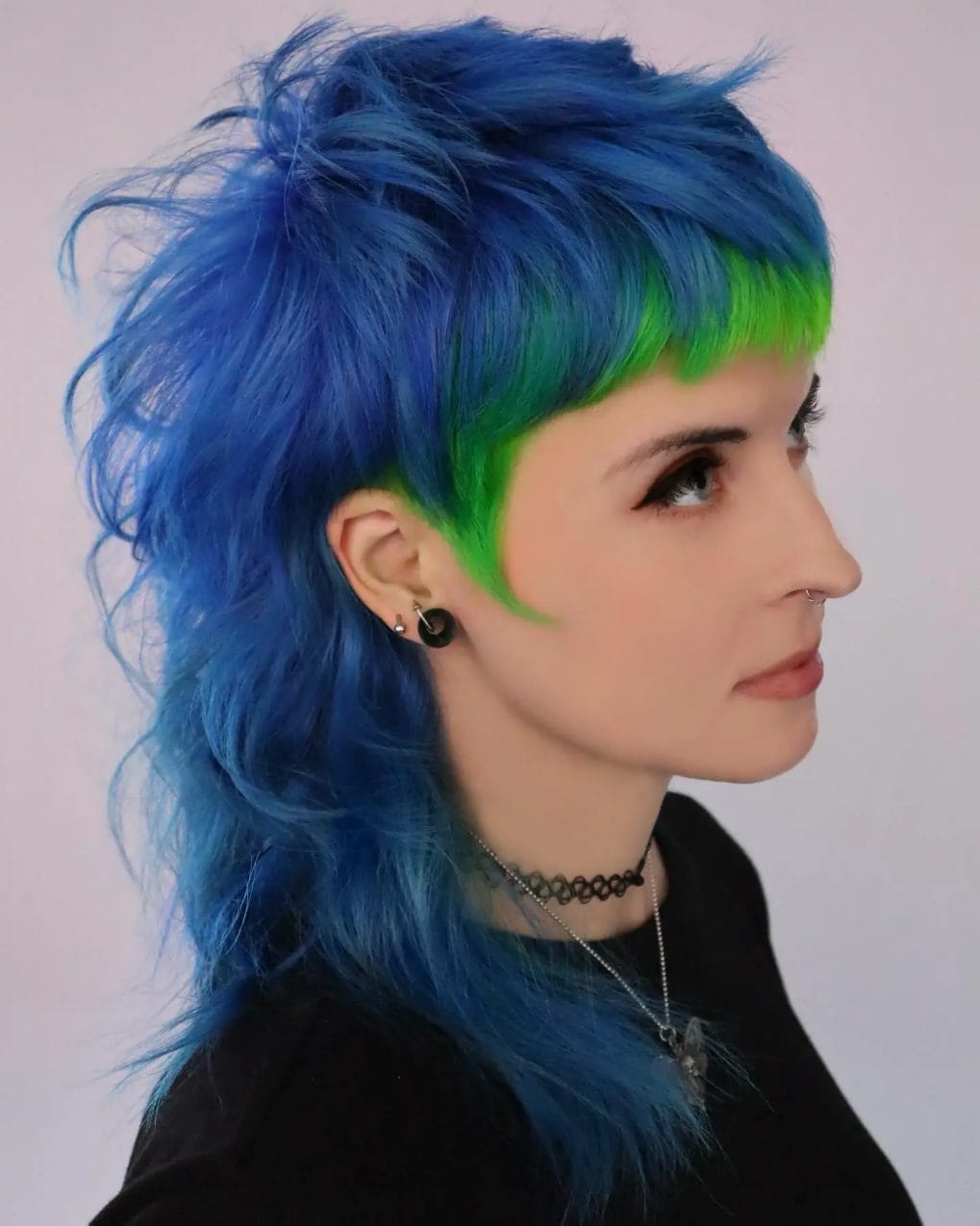 Shaggy mullet with electric blue and neon green highlights and angular bangs