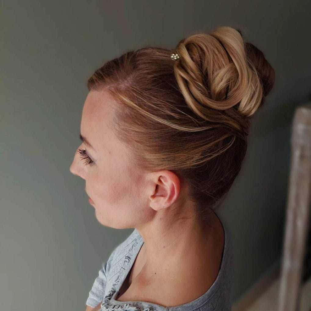 Sleek bun with intricate twists and blonde highlights.