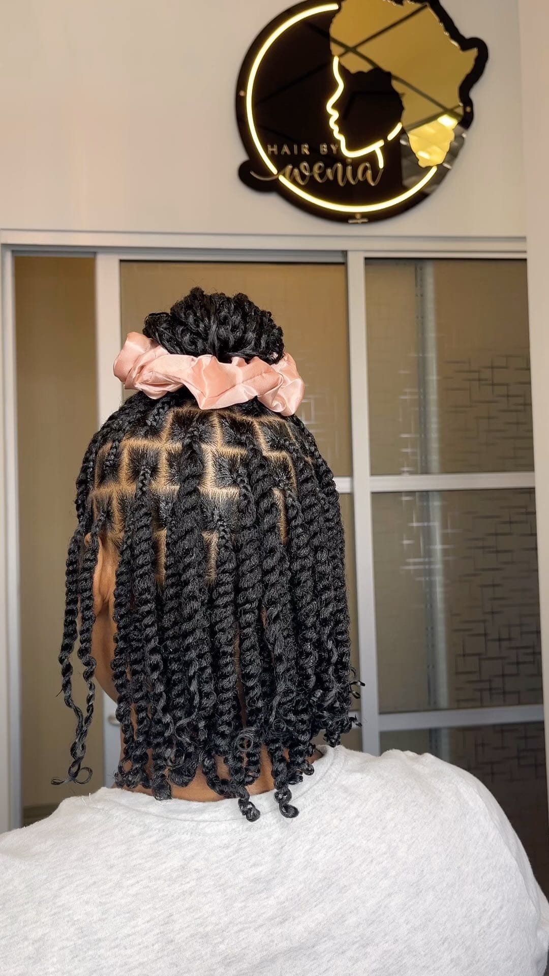 Kinky twists in an elegant updo topped with a peach scrunchie