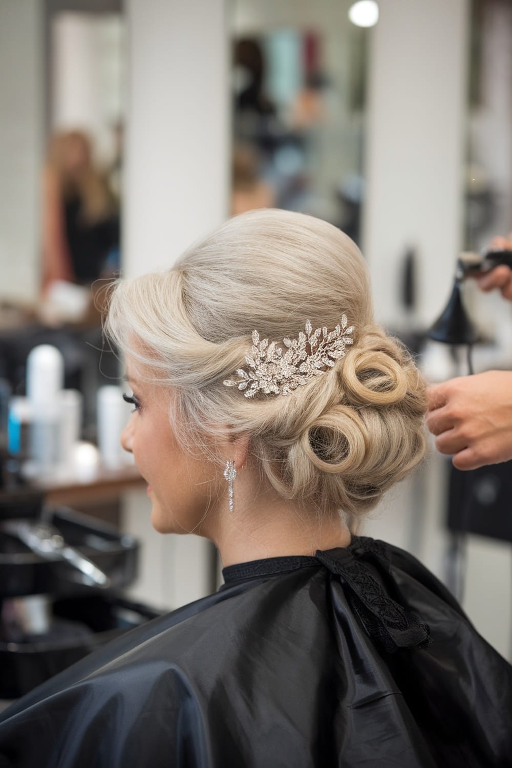 A woman with an elegant twisted hairstyle adorned with a decorative comb, preparing for a wedding.