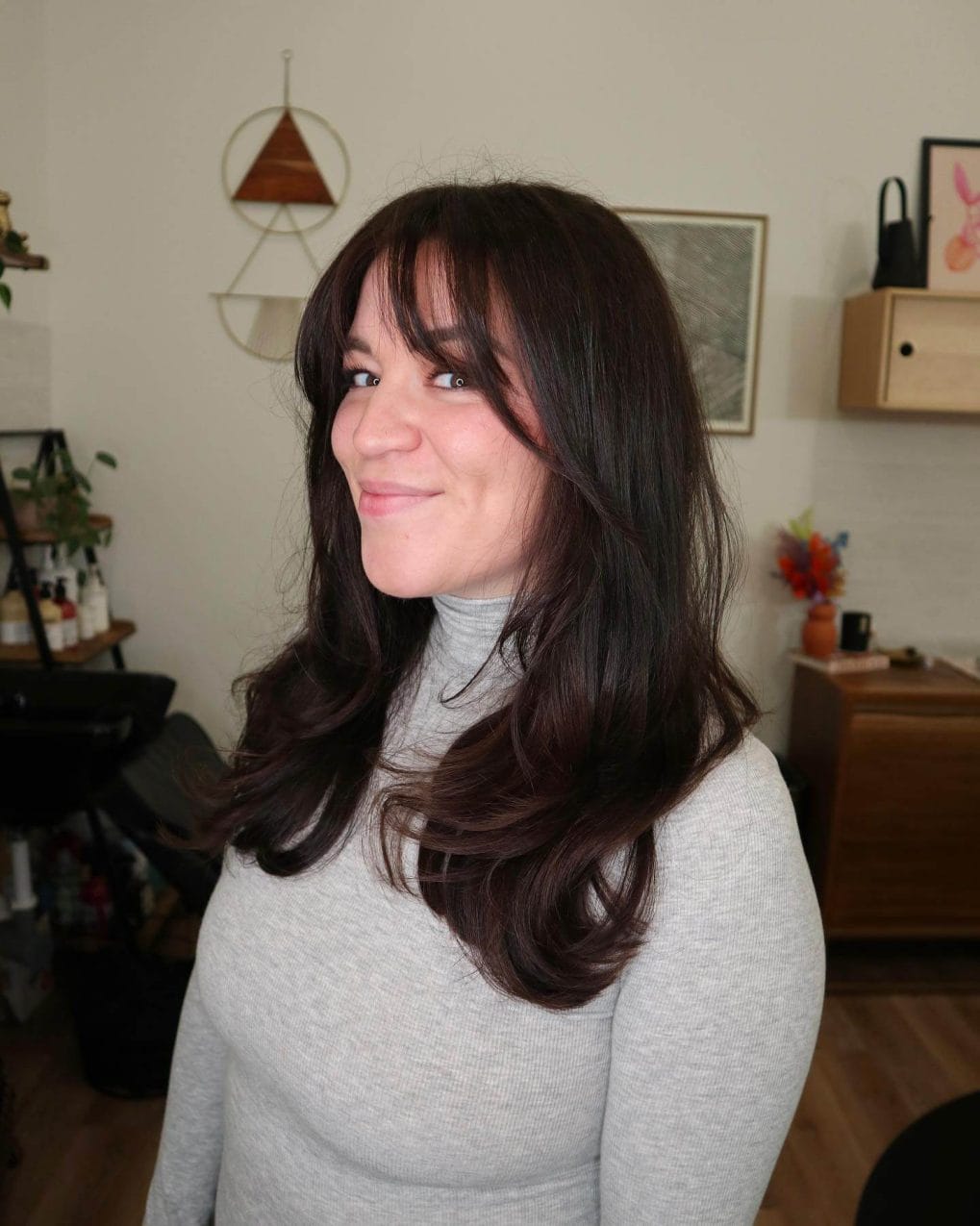 Sophisticated espresso hair with voluminous side-swept bangs.