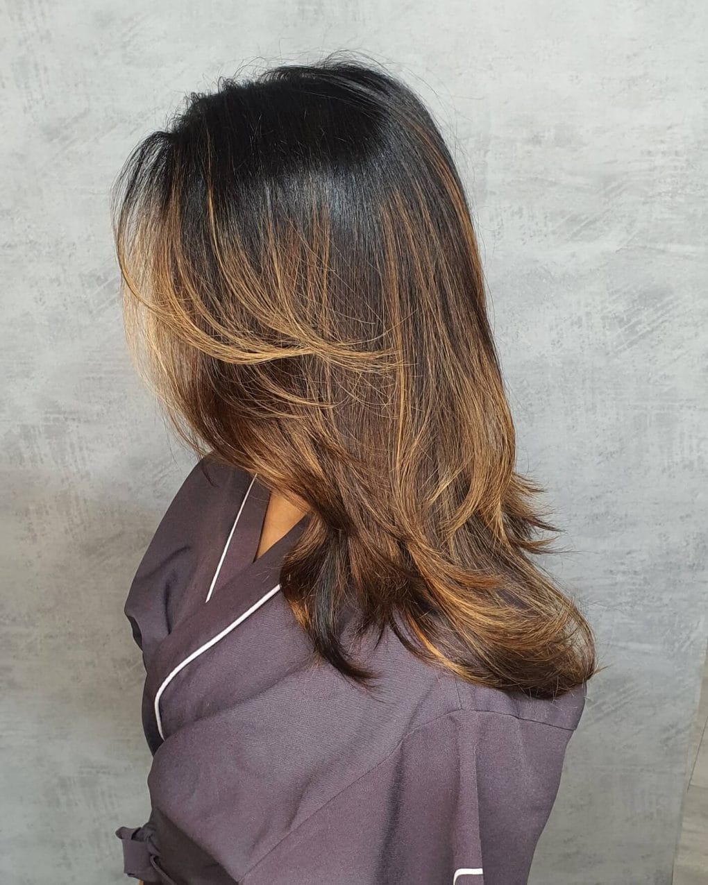 OmbrÃ© Butterfly Cut transitioning from dark roots to golden blond tips.