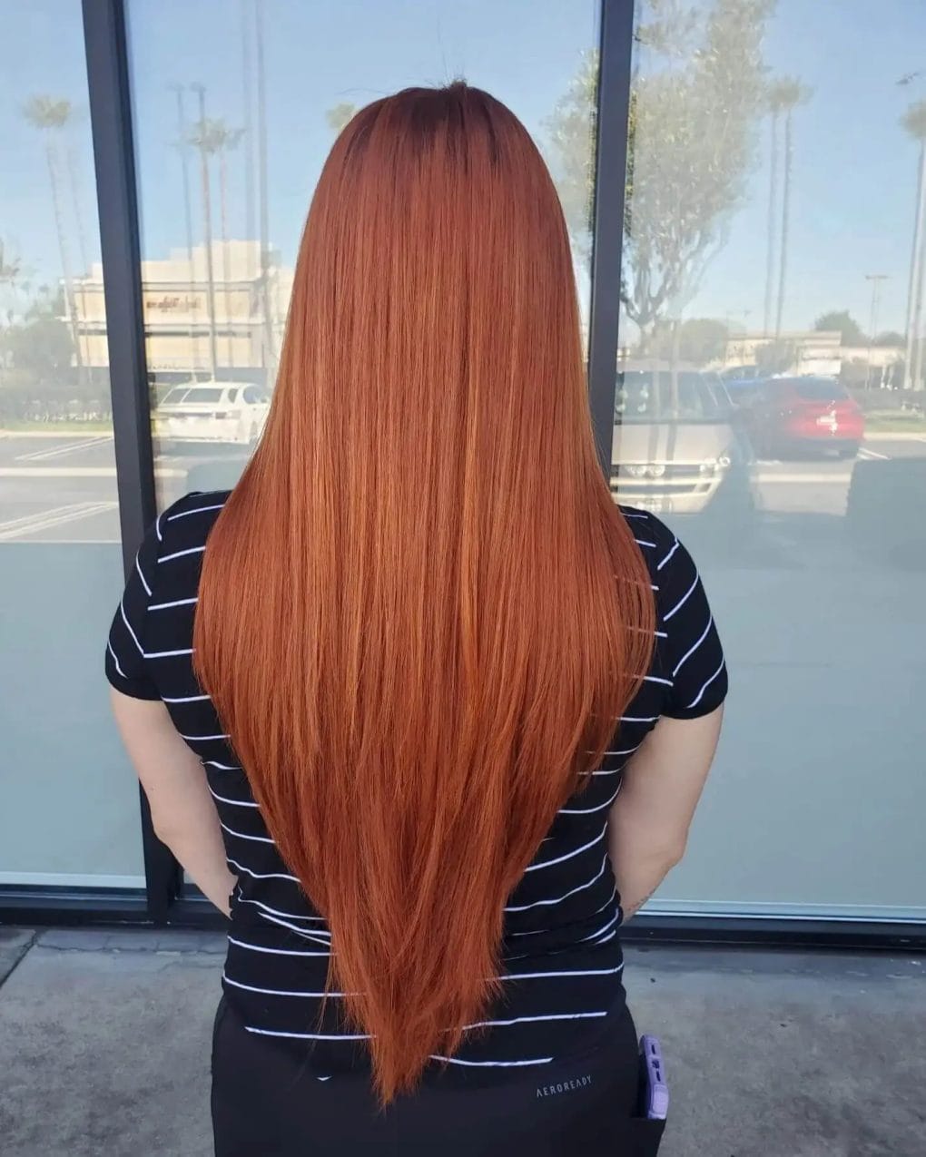 Radiant long hair in a copper shade with V-shaped layering.