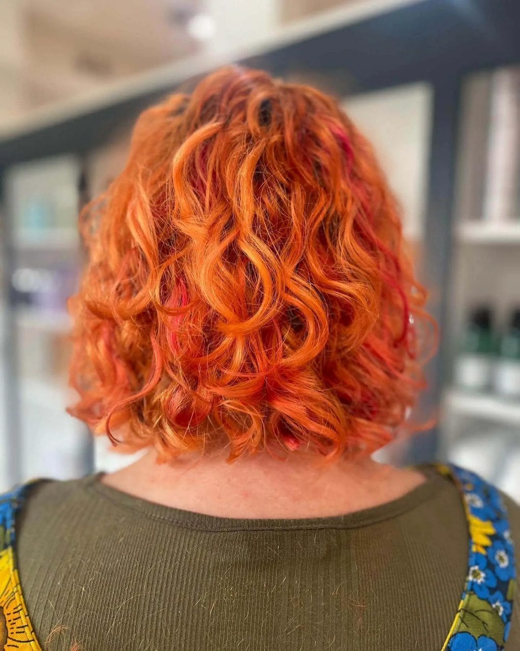 Fiery orange bob with playful pink hints and spirited curls.
