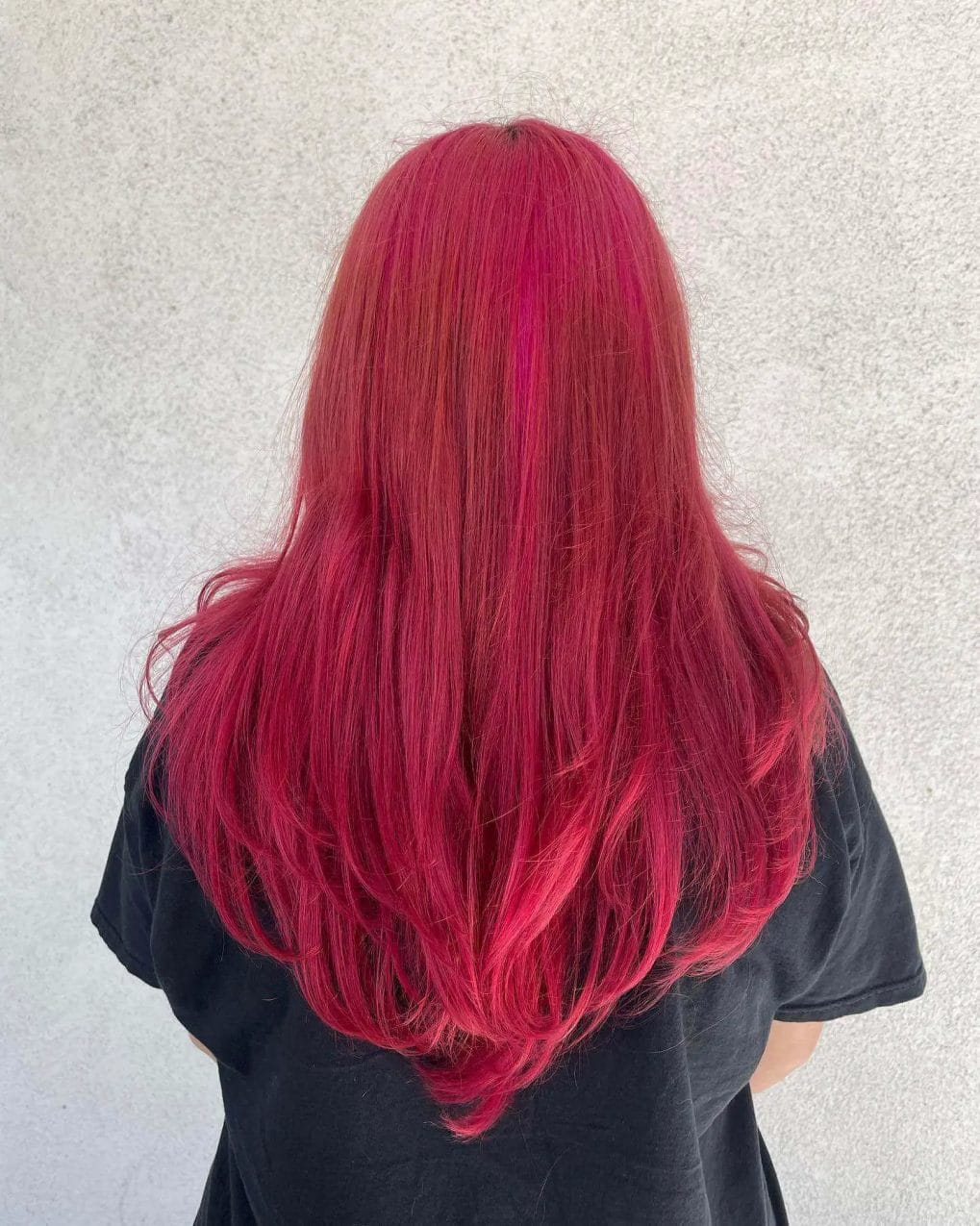 Bright red hair with a pronounced V-shaped cut for a bold look.