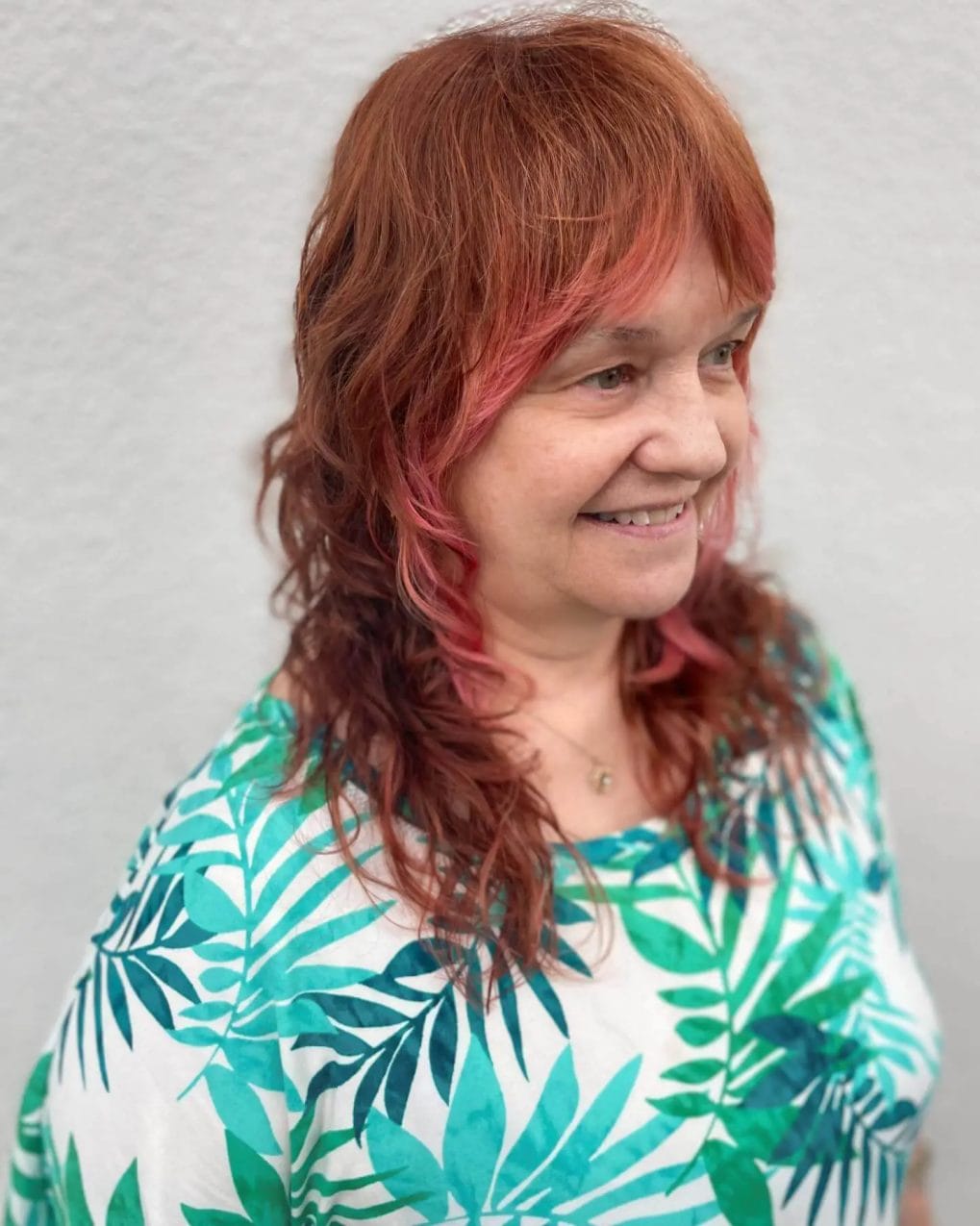 Bold red and pink shaggy mullet with soft fringe and wavy shoulder-length back