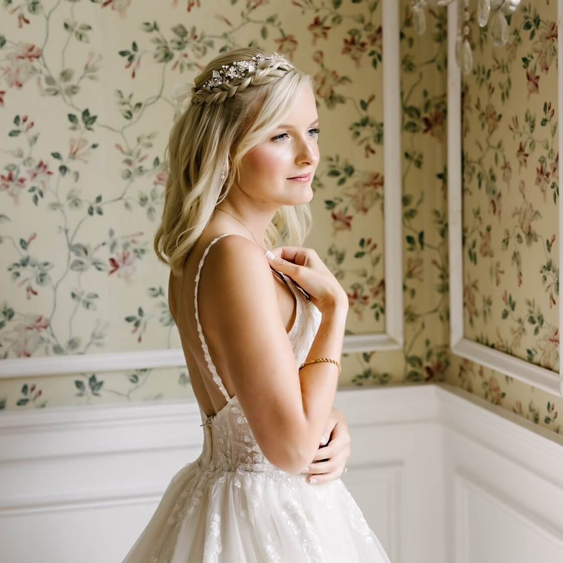 Blonde waves under a braided crown adorned with floral accessories