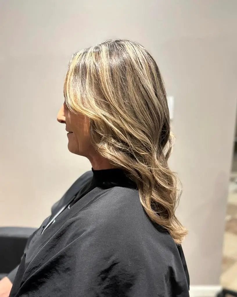 Medium-length hair with flowing layers, waves, and blended highlights.