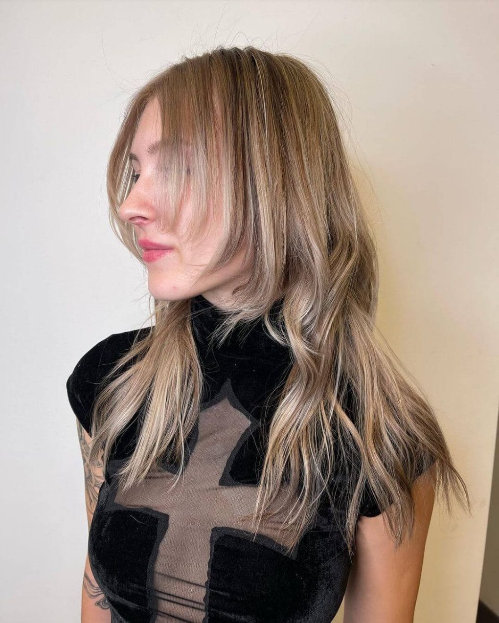 Flowing octopus haircut with sun-kissed balayage and airy side-swept fringe.