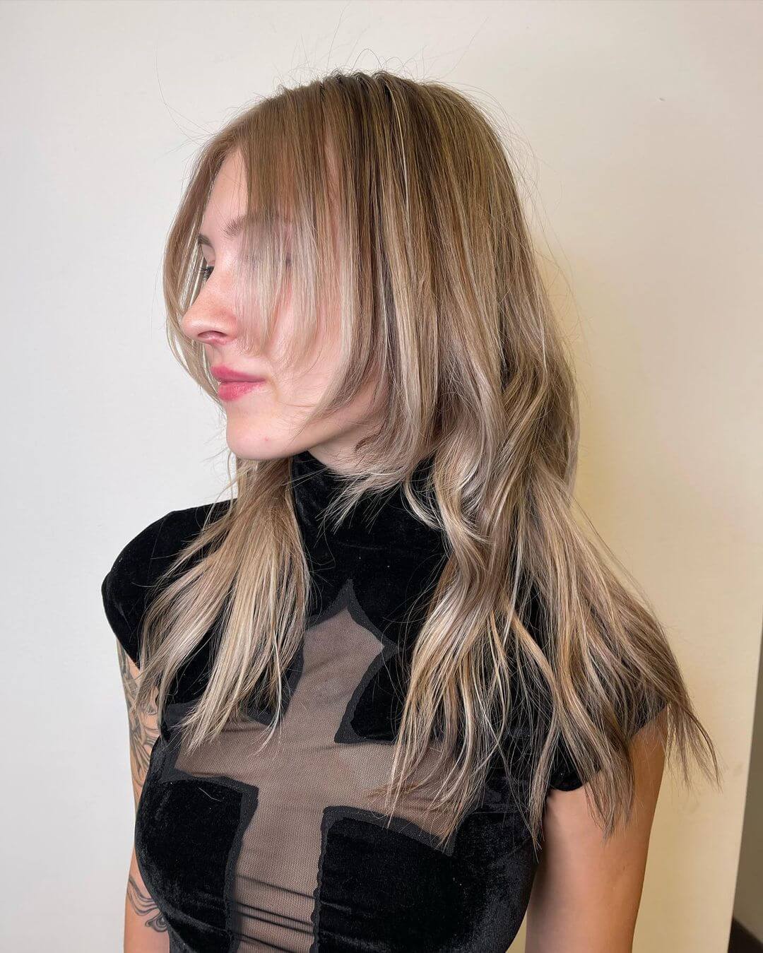Flowing octopus haircut with sun-kissed balayage and airy side-swept fringe.