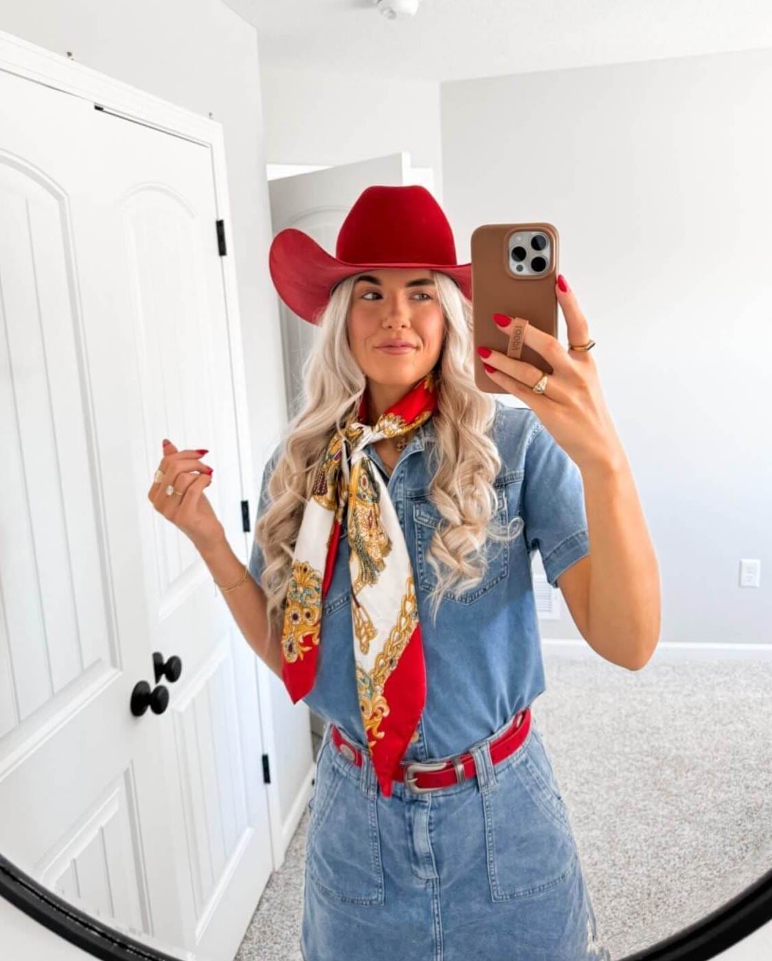 Gentle blonde curls with bright red hat for bold cowgirl style