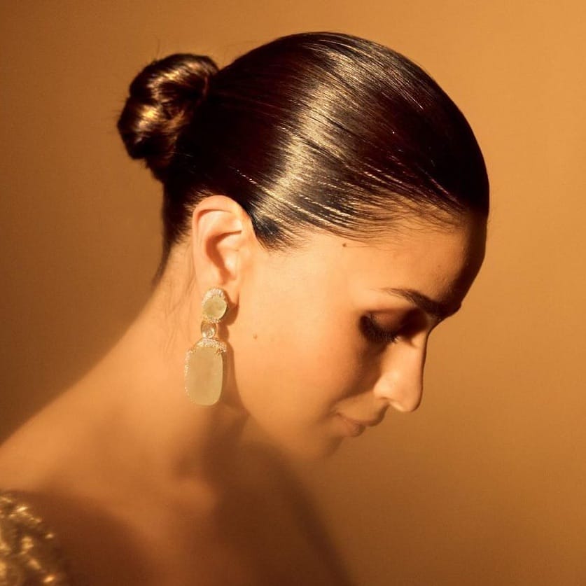 Shiny sleek bun highlighting face under dance lights