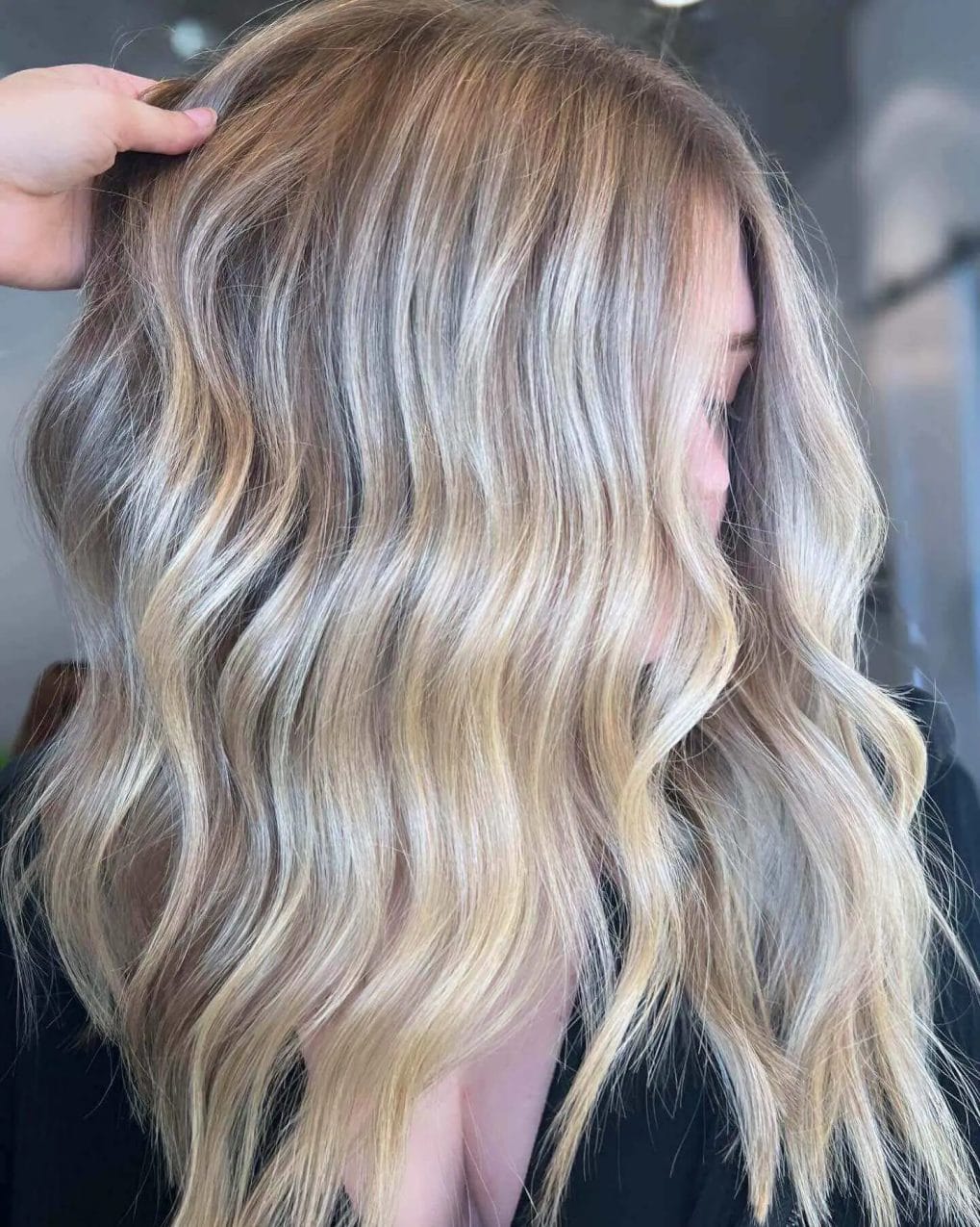 Golden ash blonde balayage with lively natural curls