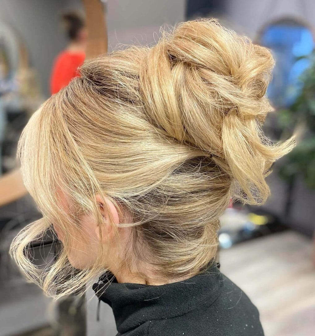 Lively golden blonde high bun with whimsical strands