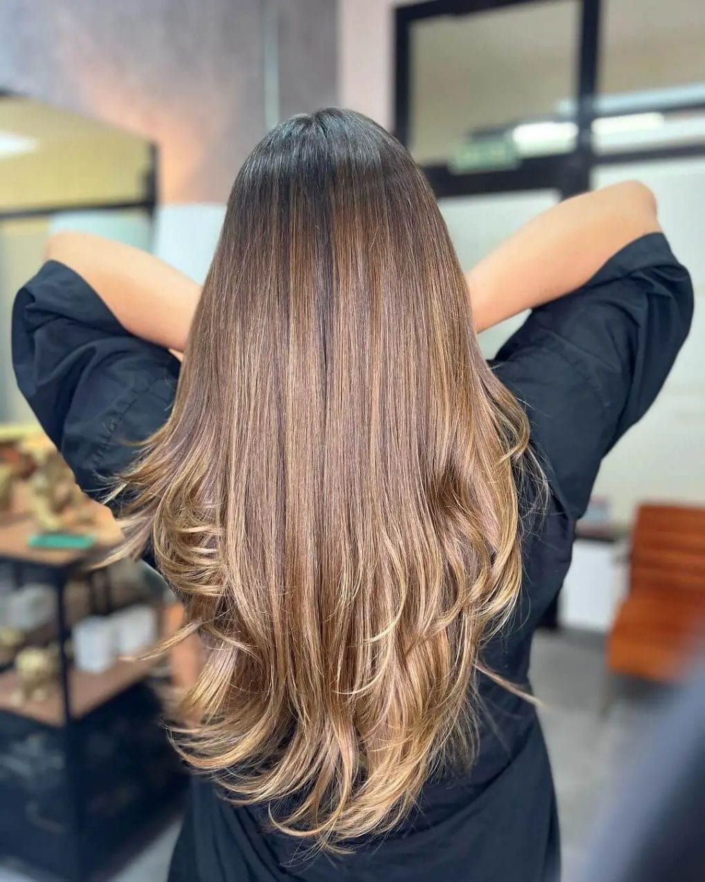 Transitioning from brunette to gold in a V-cut with a blowout finish.