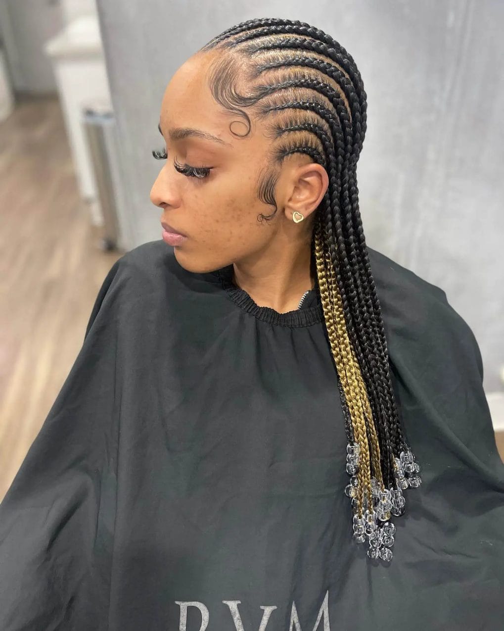 Cornrow braids with a dark to blonde gradient, detailed with clear and silver beads.