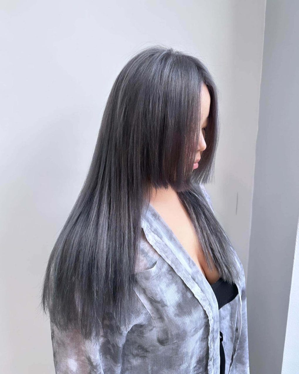 Layered straight hair with cool-toned grey balayage.