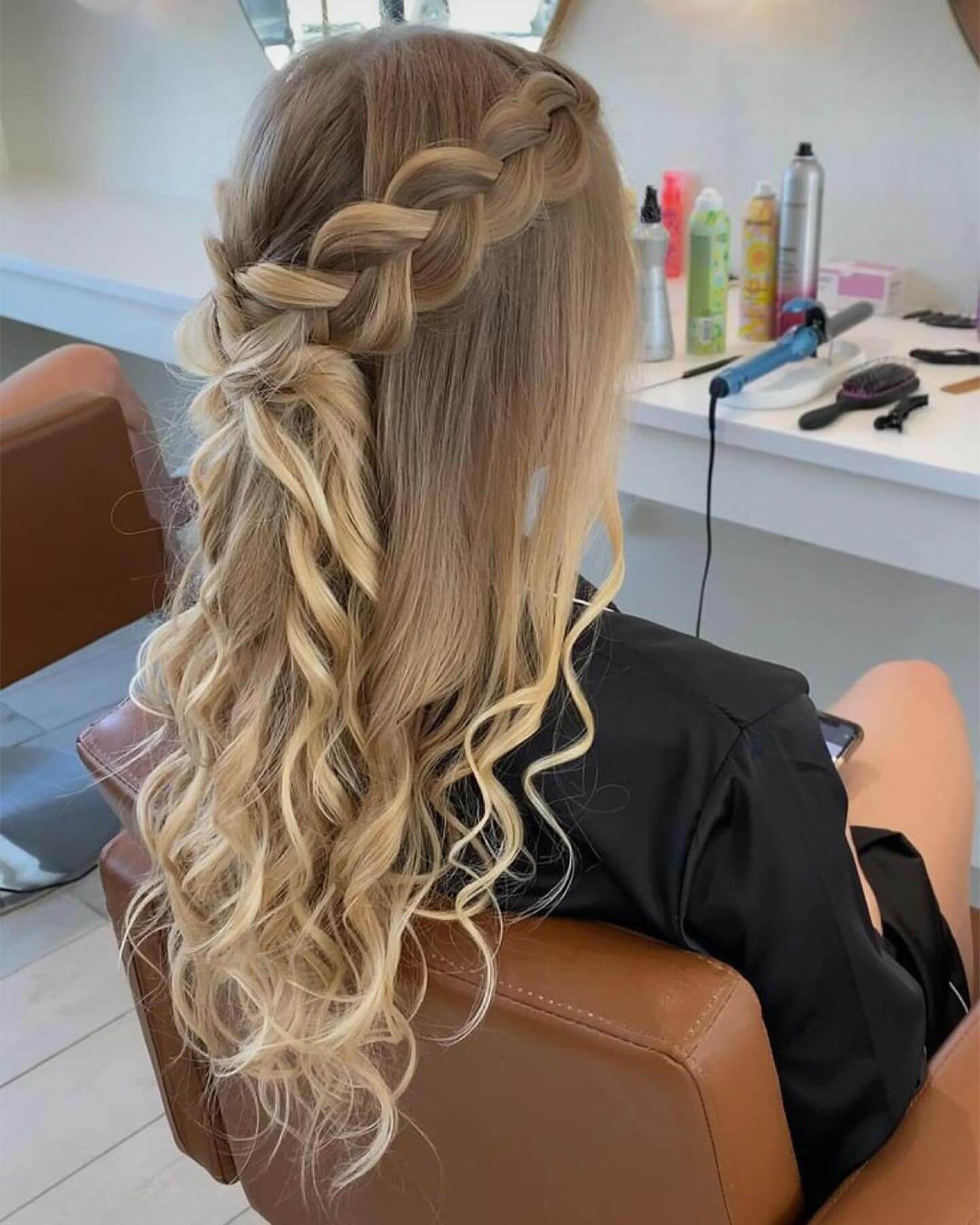 Half-up half-down blonde hair with a thick braid and loose curls