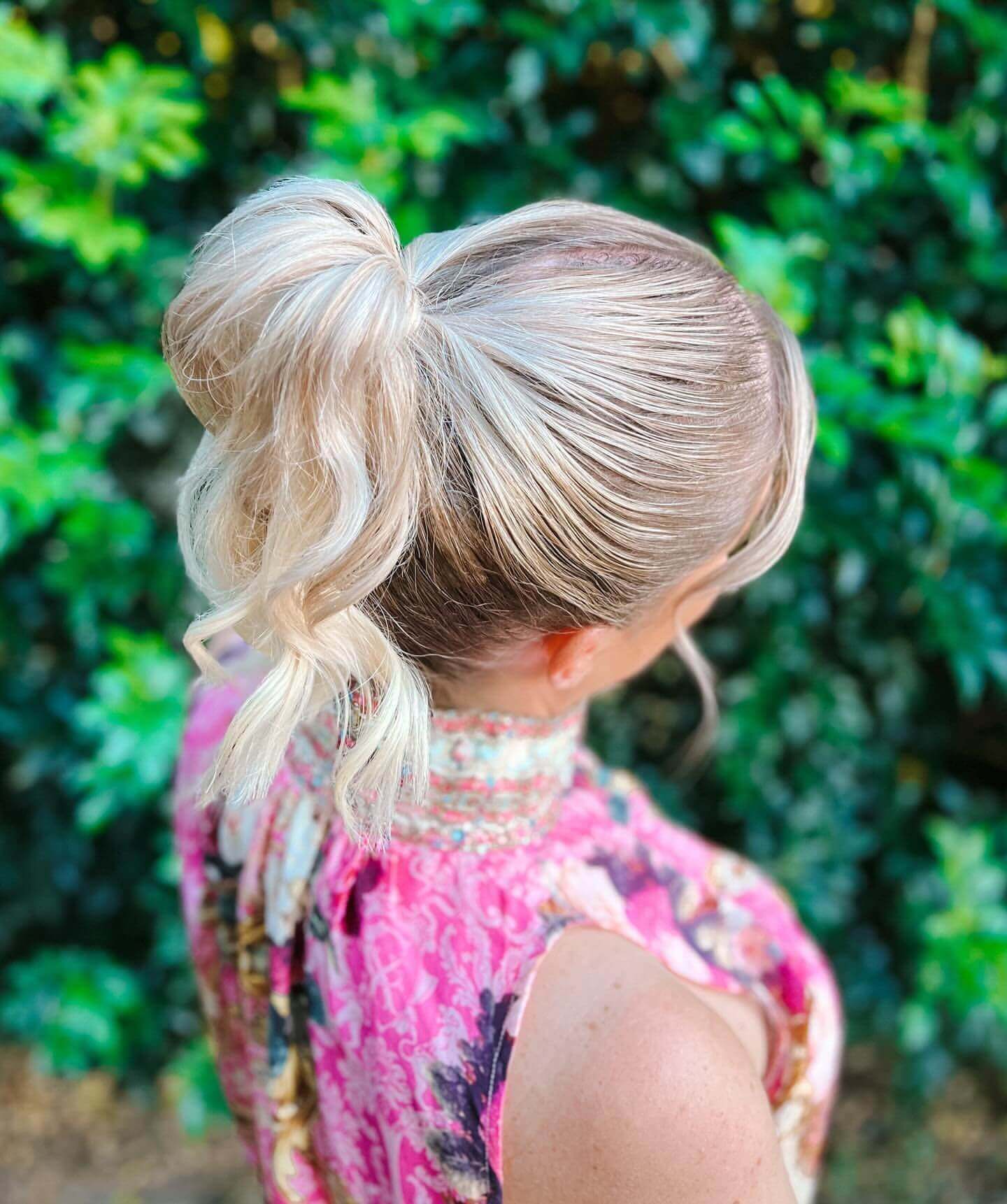 High ponytail with playful curls and sleek top.