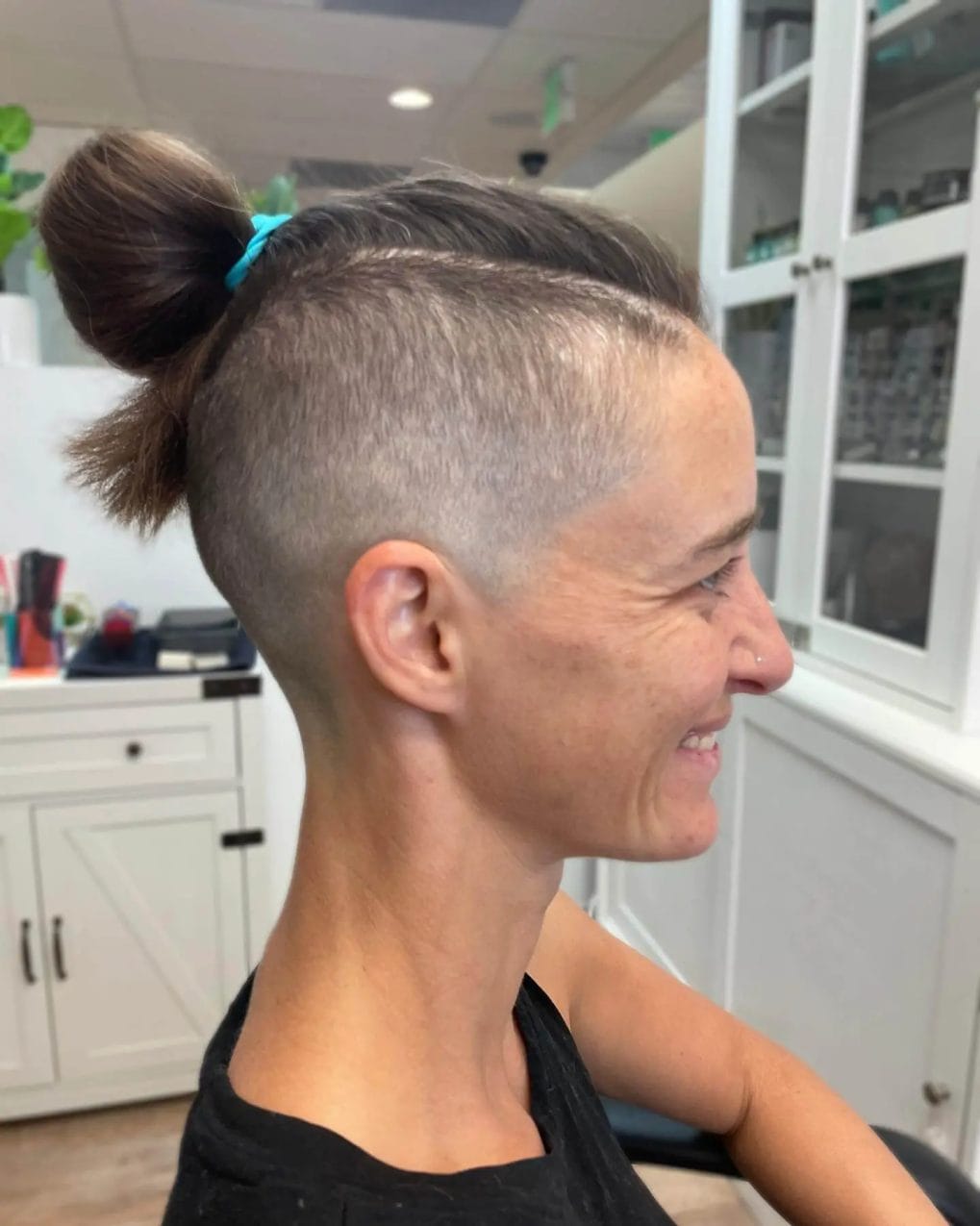 High top knot above a skillfully shaved undercut, blending into the nape.
