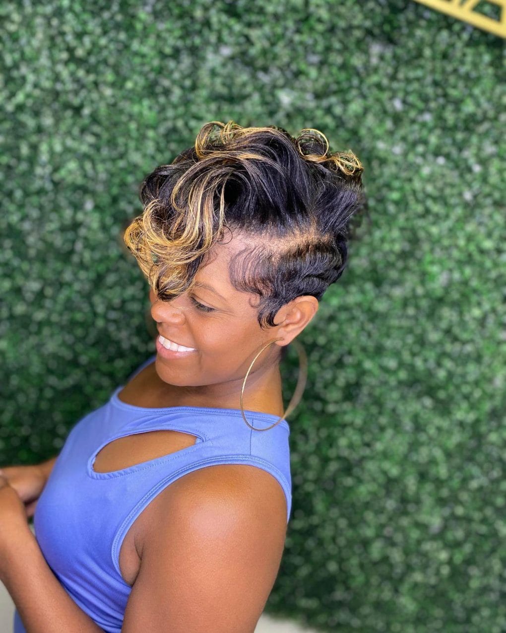 Dark wavy pixie illuminated by blonde highlights with a dramatic front bang.