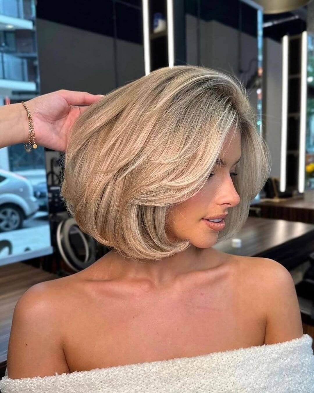Layered honey blonde bob with side-swept bangs