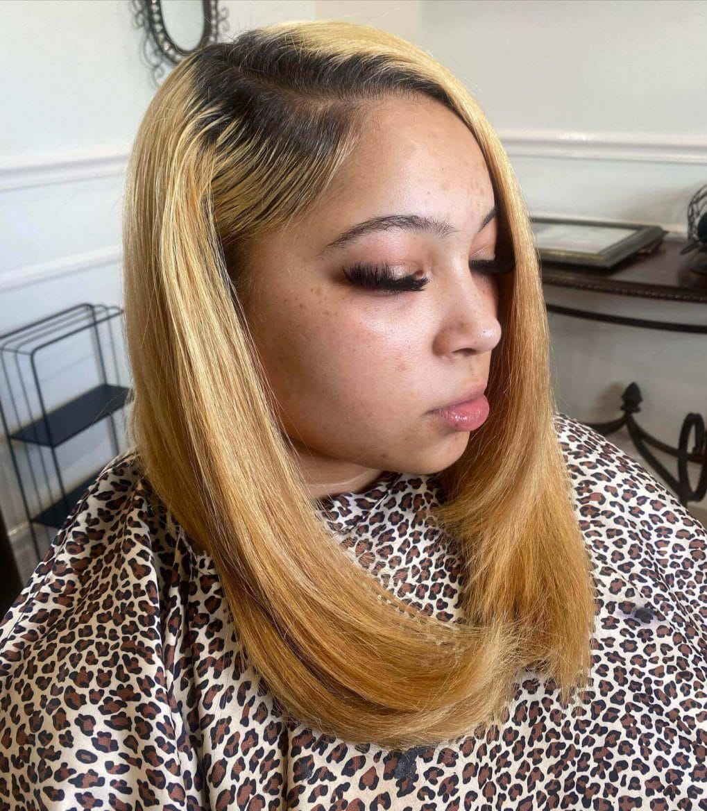 Long silk press in bold honey-blonde with darker roots and slightly curled ends