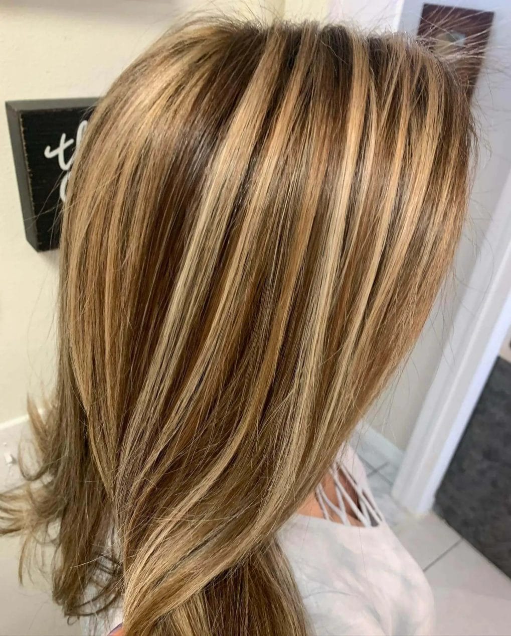 Long layers with honey and caramel chunky highlights, face-framing and voluminous.